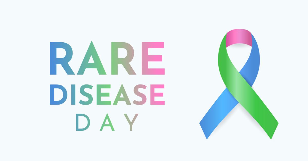 Text reading "Rare Disease Day" in gradient colors of blue, green, and pink, next to a ribbon with three colors: pink at the top, green on the right, and blue on the left.