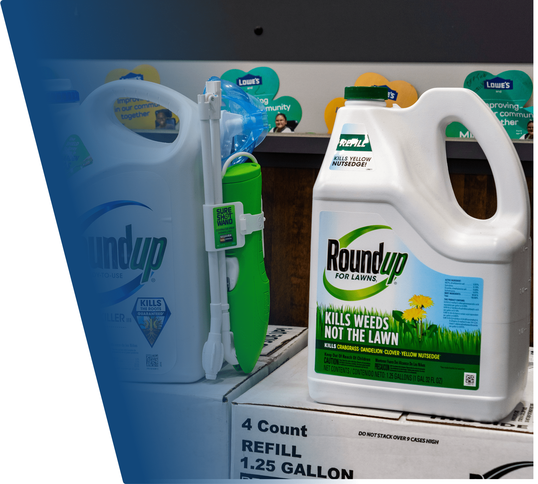A 1.25-gallon white container of Roundup weed killer for lawns, labeled "Kills Weeds Not The Lawn," with a green cap and a green and black label featuring grass and yellow dandelions. The container is placed on a box labeled "4 Count Refill 1.25 Gallon." Another similar Roundup container with a green spray wand attached is partially visible behind it.